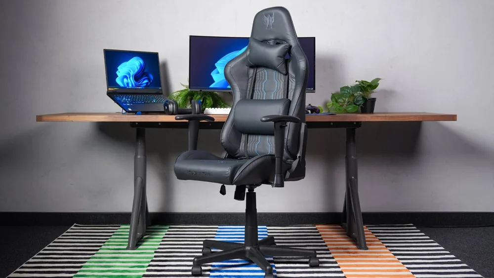 Noutbuk va monitorli ish stoli oldidagi Acer Predator Rift Go