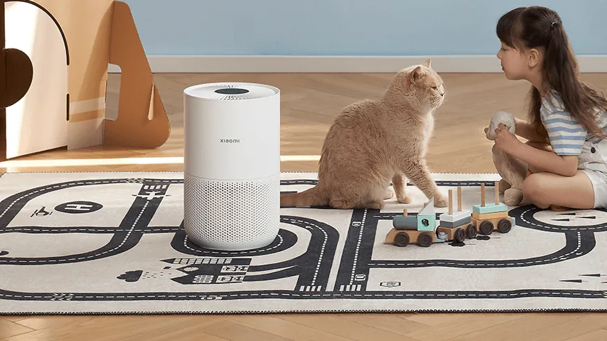 Bolalar xonasida qizcha va mushuk yonidagi Xiaomi Smart Air Purifier 4 Compact — filtr jun va qazgʻoqni ushlaydi