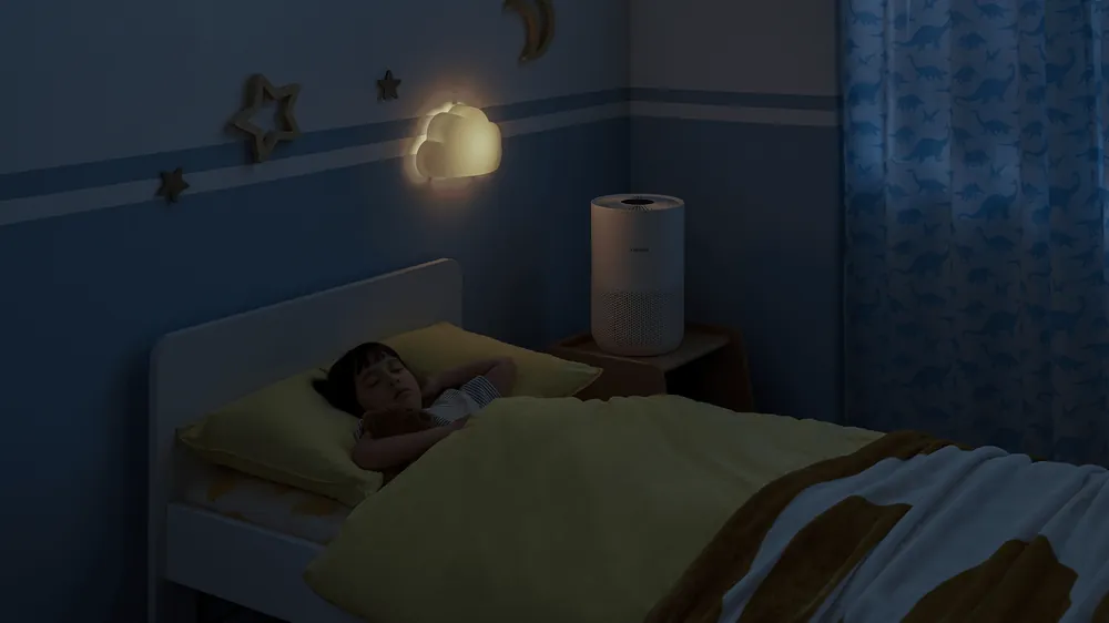 Qorongʻi bolalar xonasida tumbochkadagi Xiaomi Smart Air Purifier 4 Compact — uyqu rejimi 20 dB dan