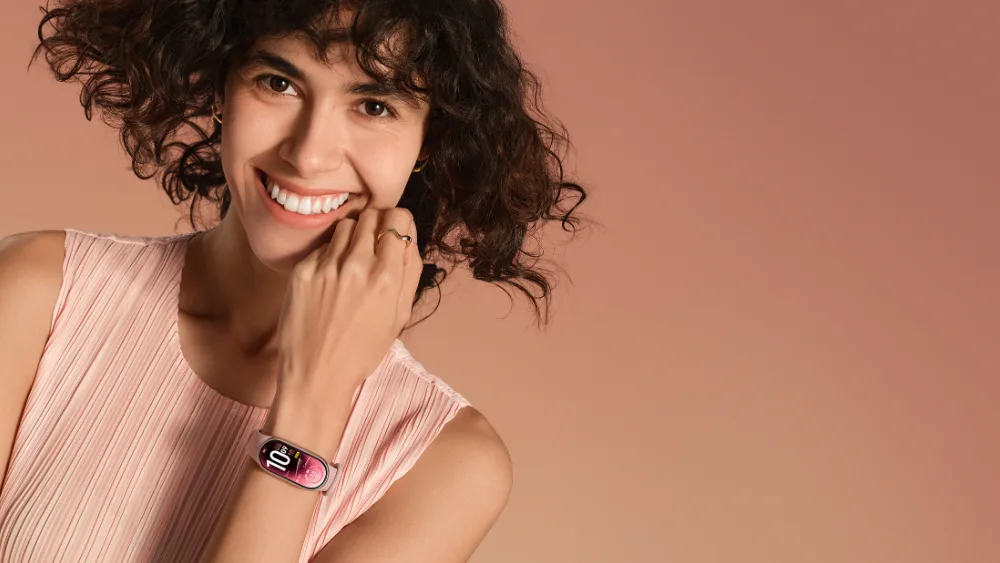 Qiz jilmaymoqda, qoʻlida pushti tasmali Xiaomi Smart Band 11 — tasmasiz 15,58 g