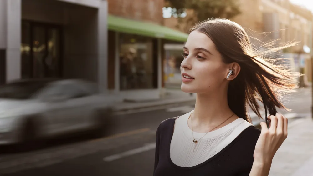 Shamolli koʻchada Xiaomi Buds 5 taqqan qiz — uchta mikrofon 12 m/s gacha shamolda ham ovozni ushlab turadi