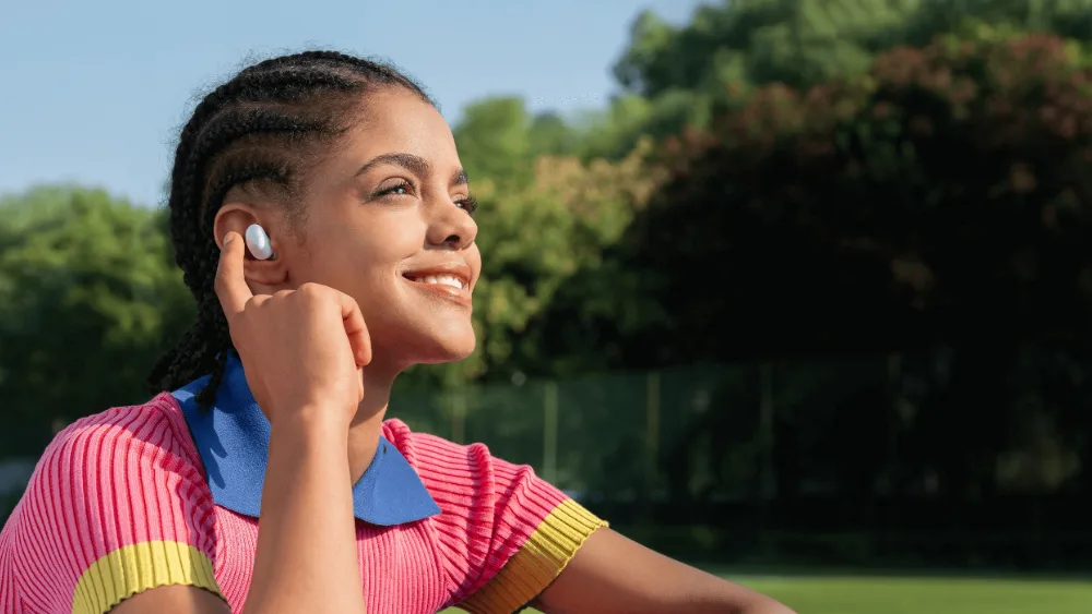 Qulogʻidagi Redmi Buds 6 Play quloqchinini toʻgʻrilayotgan qiz — quloqchin 3,6 g