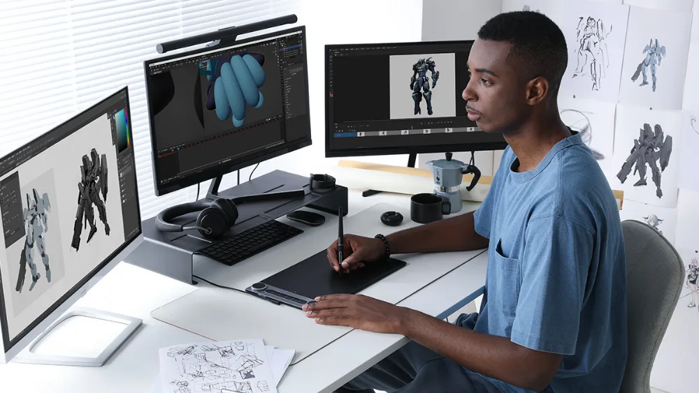 Uchta monitorli stol ortida Huion Inspiroy Dial 2 da 3D model va animatsiya bilan ishlash
