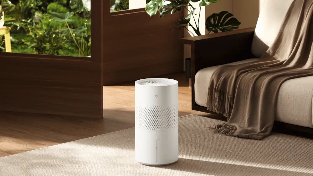 Mijia Smart Evaporative Humidifier Pro divan yonidagi gilamda turibdi, ustida tuman koʻrinmaydi