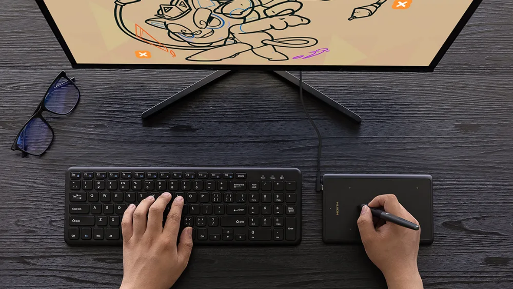 Klaviatura yonidagi kichik Huion Inspiroy H420X: bir qoʻl tugmalarda, ikkinchisi pero bilan chizadi