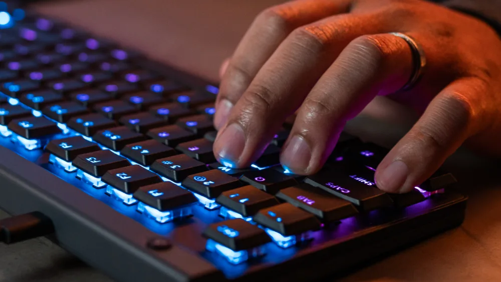 Qoʻl koʻk yoritishli Logitech G515 RAPID TKL ning past tugmalarini bosmoqda