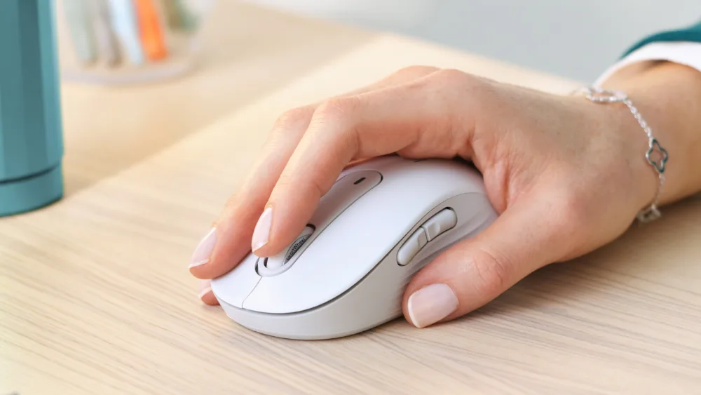 Och rangli stoldagi oq Logitech Signature M650 sichqonchasida qoʻl