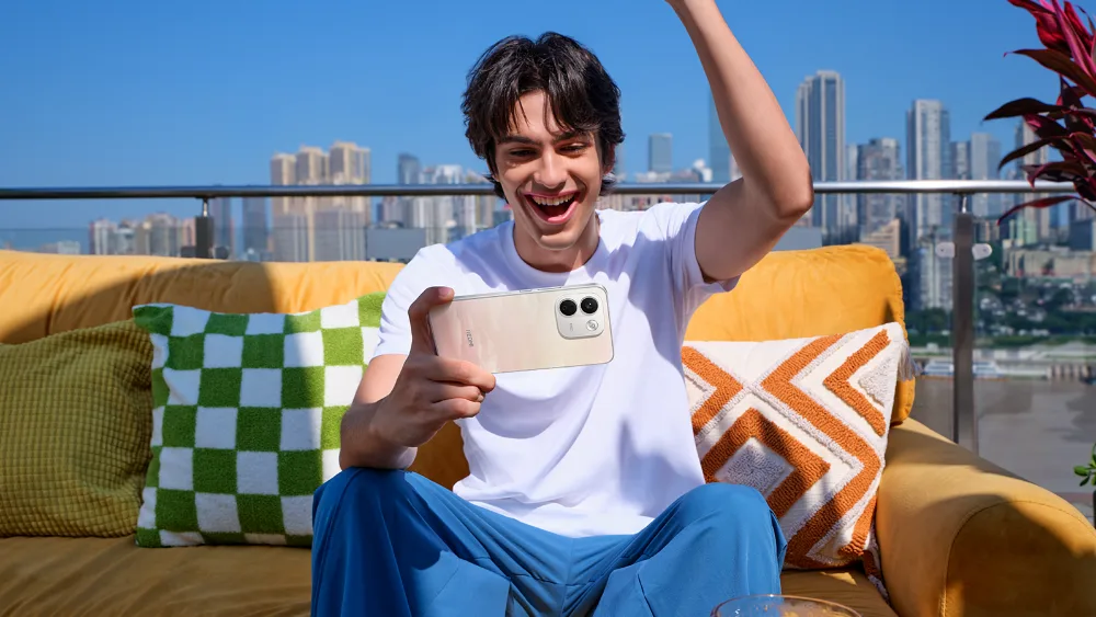 Terrasadagi divanda yigit Redmi Note 17 Pro Max 5G da oʻyindan quvonmoqda — 10 000 mA·soat batareya