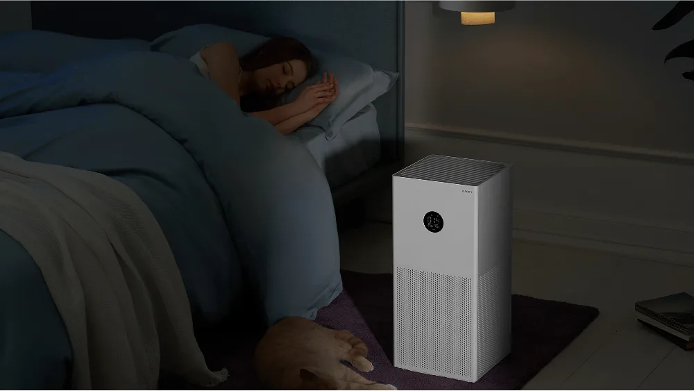Tunda yotoqxonada Xiaomi Smart Air Purifier 4 Lite, karavot yonida mushuk uxlayapti