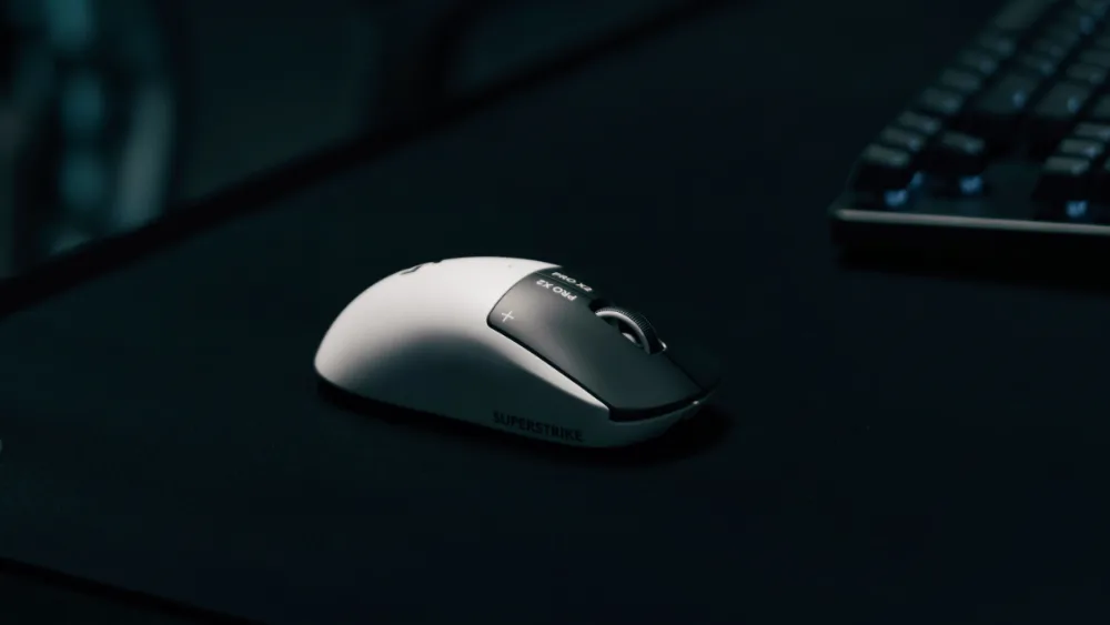 Logitech G PRO X2 SUPERSTRIKE на тёмном коврике рядом с клавиатурой