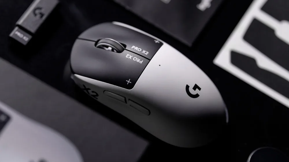 Logitech G PRO X2 SUPERSTRIKE на столе рядом с накладками для хвата из комплекта