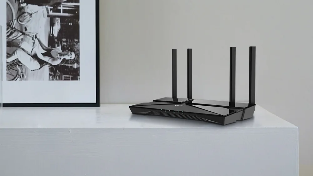 Роутер TP-Link Archer AX23 на белой полке рядом с картиной