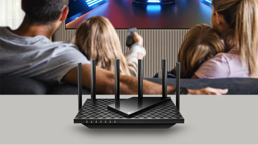 Роутер TP-Link Archer AX72 перед семьёй, которая играет у телевизора