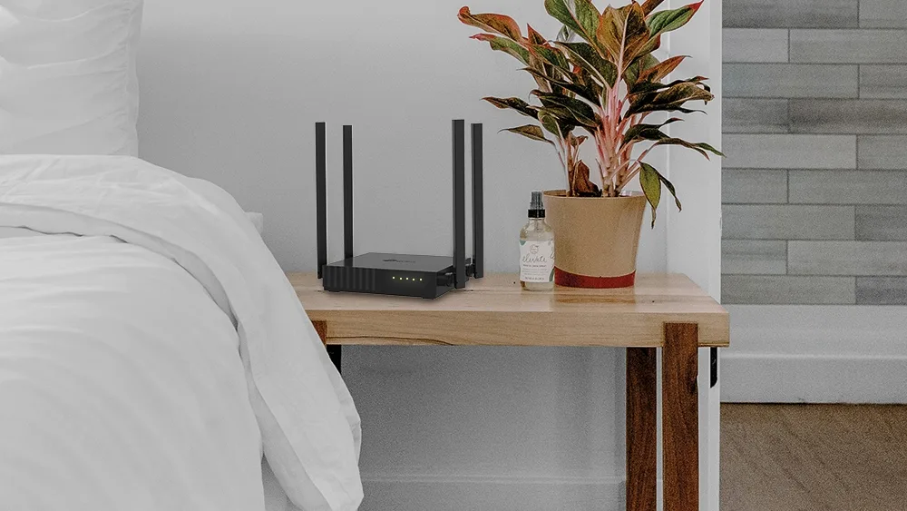 Роутер TP-Link Archer C54 на прикроватной тумбе в спальне