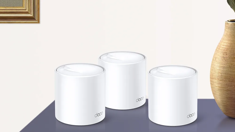 Три модуля Mesh-системы TP-Link Deco X20 на тумбе в комнате
