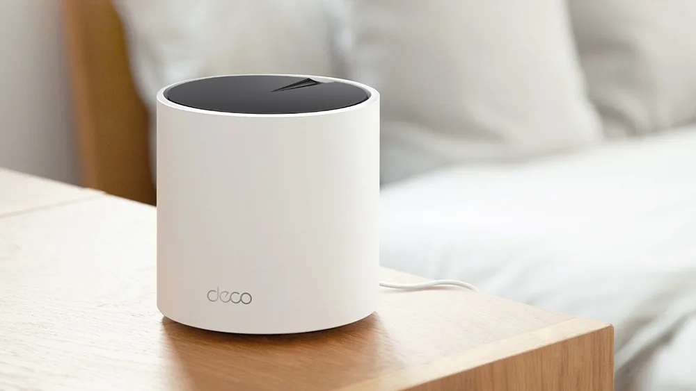 Модуль Mesh-системы TP-Link Deco X55 на тумбе у дивана